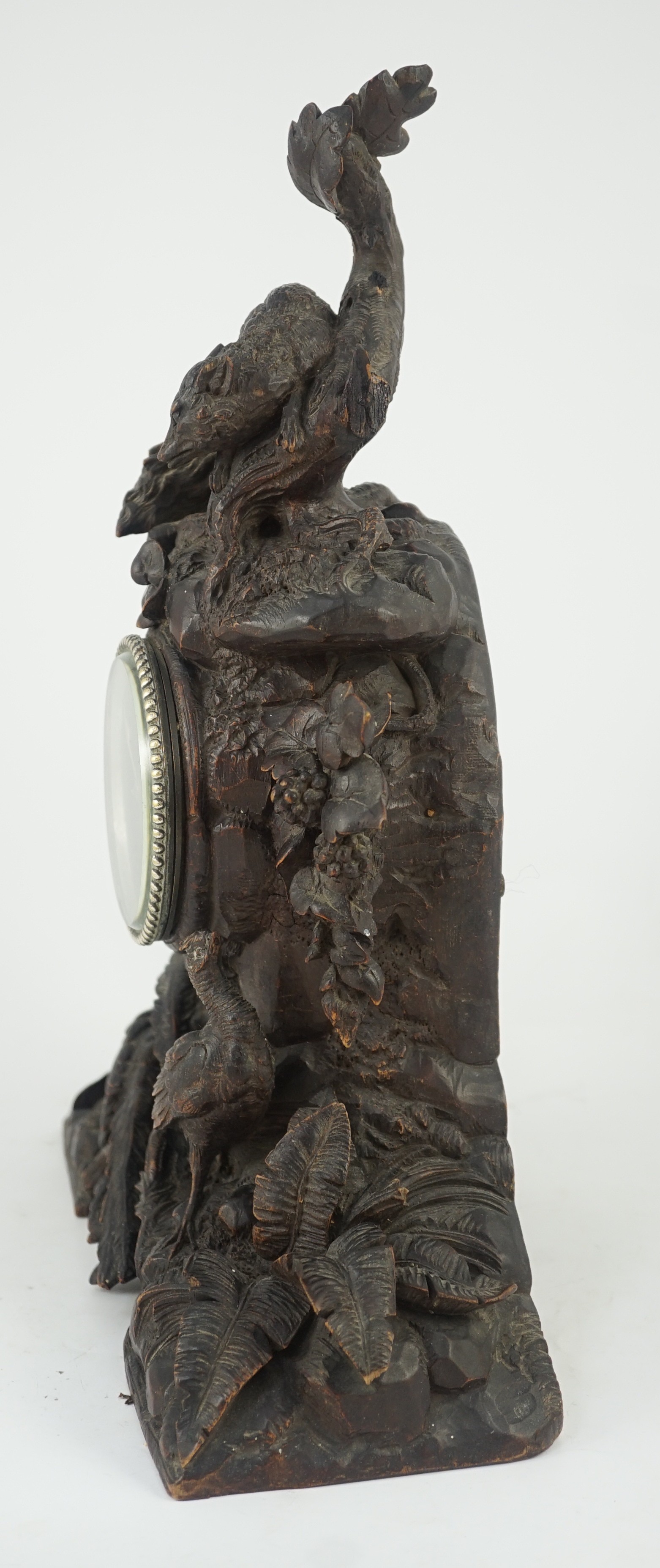 A 19th century Black Forest carved wood mantel timepiece, 30cm wide, 38cm high